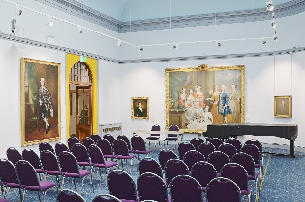 Chairs lined up in front of a grand painting