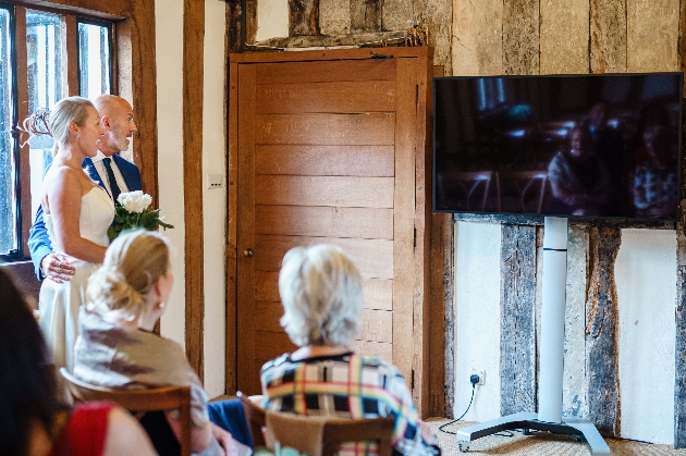 Bride and groom getting married in front of a TV