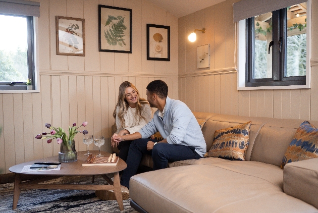 couple sat on leather sofa in a cabin like room