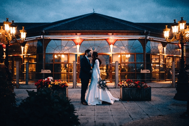 A bride and groom standing in front of The Lake at Barston