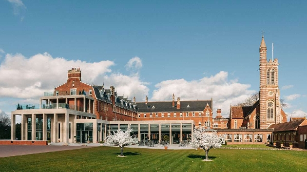 A grand red brick building with a cathedral attached to it