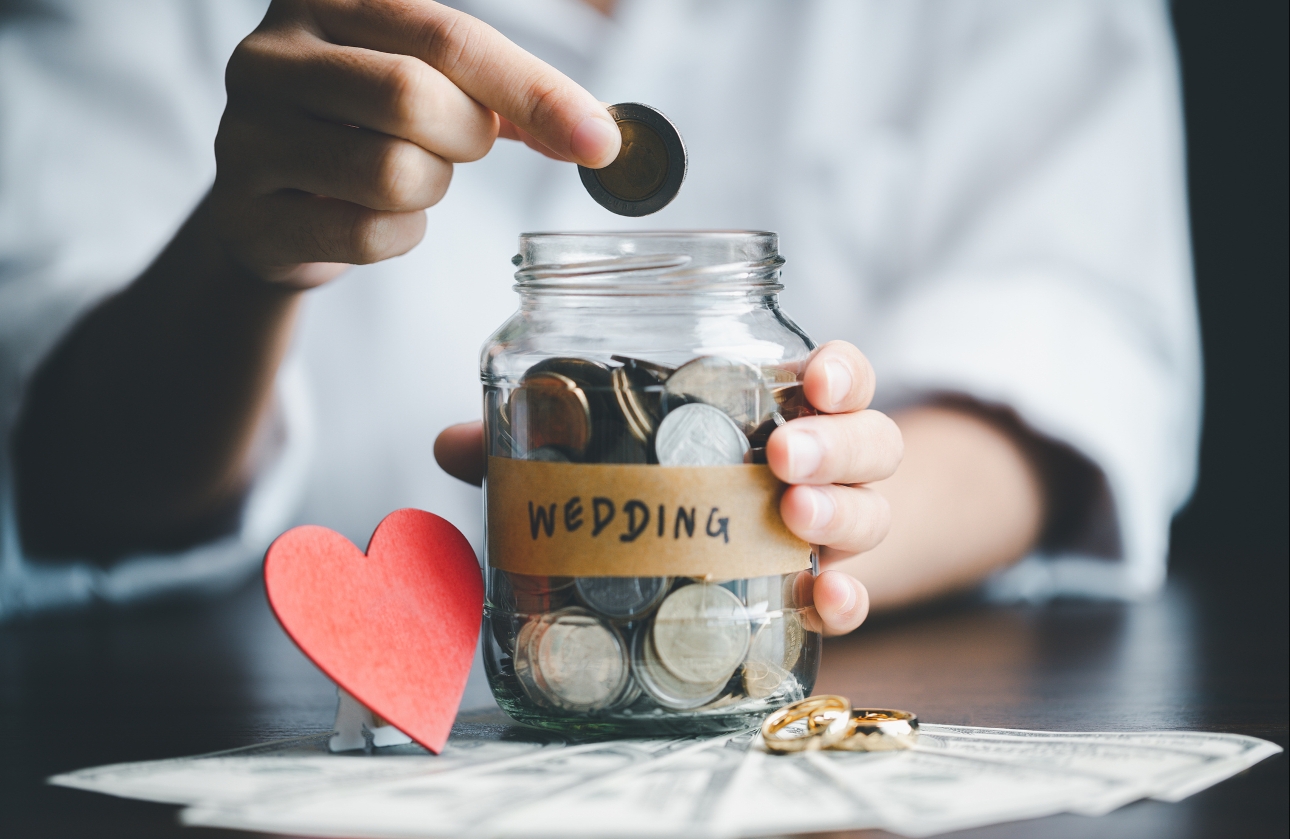 money saving jar with pennies in it, hand putting more in. 