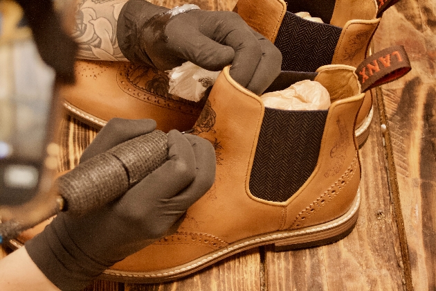 A man tattooing a pair of shoes