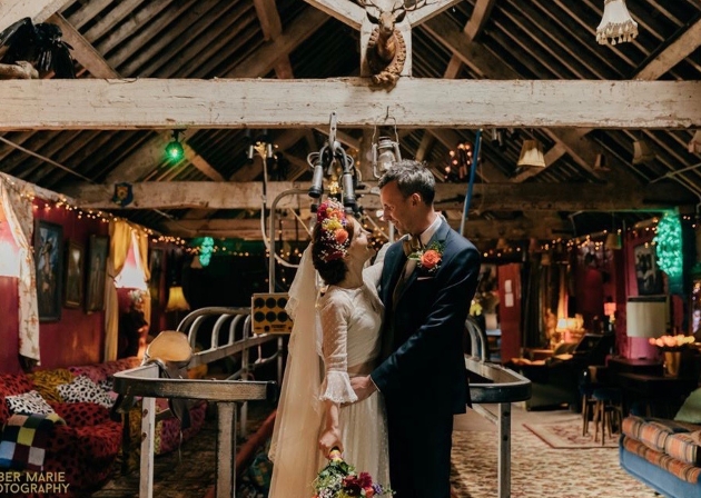 Bride and groom embracing in a rustic barn