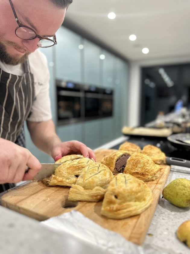 A chef cutting pastries in half