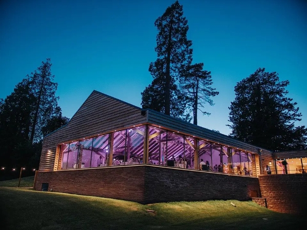 The exterior of a wood-clad venue with windows along two walls