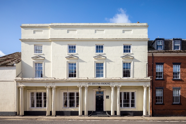 The exterior of a large white building with lots of windows