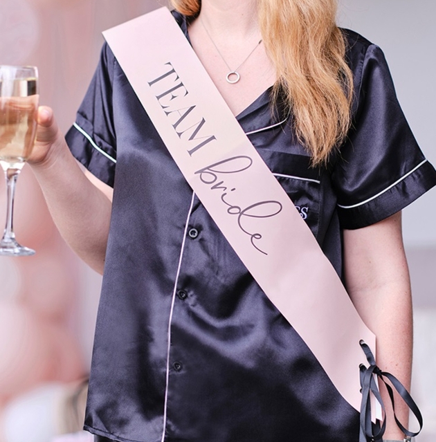 woman in PJs with a team bride banner on her 