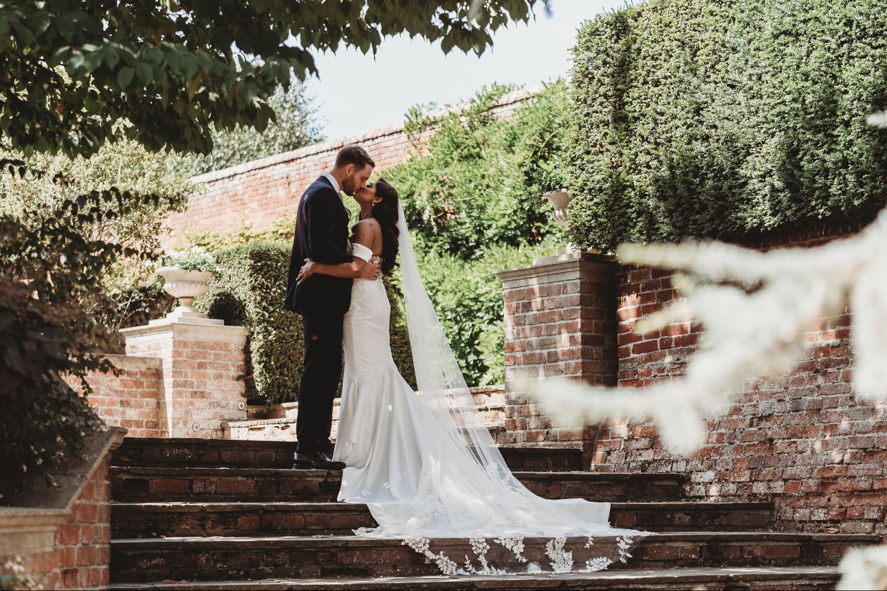 couple standing on stone steps at braxted park in essex