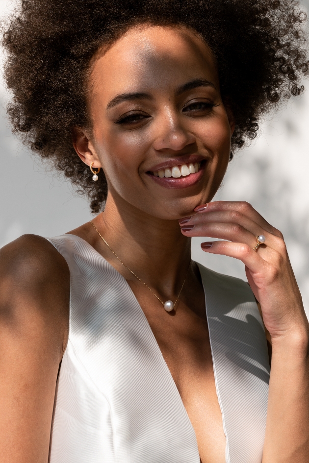 bride in white dress with pearl earrings, necklace and ring